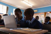 Estudantes usando laptop na sala de aula na escola — Fotografia de Stock