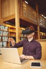 College student using laptop and virtual reality headset in library — Stock Photo