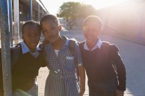 Школьники, стоящие в школьном городке в солнечный день — стоковое фото
