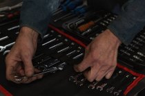 Close-up of mechanic arranging tools in garage — Stock Photo