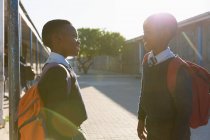 Школьники смотрят друг на друга в школьном городке в солнечный день — стоковое фото