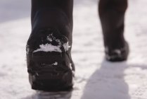 Niedriger Abschnitt des Menschen, der auf einer verschneiten Region geht — Stockfoto