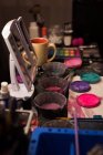 Close-up de várias tintas e maquilhagem mantidas na mesa — Fotografia de Stock
