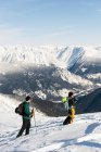 Skieurs et skieuses marchant sur une montagne enneigée pendant l'hiver — Photo de stock