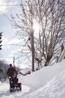 Homem usando máquina de ventilador de neve na região nevada — Fotografia de Stock