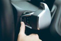 Empresária apertando o botão iniciar parada em um carro — Fotografia de Stock