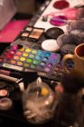 Close-up of various paint and make-up box kept on table — Stock Photo