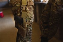 Средняя секция военнослужащего, стоящего с пистолетом во время военной подготовки — стоковое фото