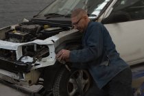 Masculino mecânico manutenção carro roda na garagem — Fotografia de Stock