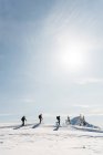 Группа лыжников, идущих на снежную гору зимой — стоковое фото