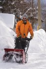 Mann benutzt Schneefräse im Winter in verschneiter Region — Stockfoto