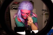 Donna che si dipinge il viso con il pennello per la celebrazione di Halloween — Foto stock