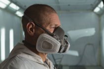 Close-up of mechanic with gas mask in garage — Stock Photo