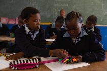 Des écoliers tenant des stylos à dessin en classe à l'école — Photo de stock