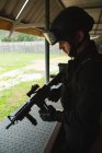 Seitenansicht eines Soldaten, der während der militärischen Ausbildung mit dem Gewehr steht — Stockfoto