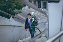 Joven hombre de negocios subiendo escaleras con bicicleta - foto de stock