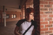 Портрет студента колледжа, стоящего в коридоре — стоковое фото