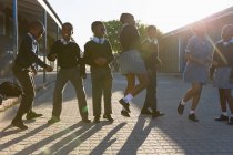 Школярки розважаються в шкільному кампусі в сонячний день — стокове фото