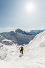 Caminhada de esqui com prancha de esqui em uma montanha nevada durante o inverno — Fotografia de Stock