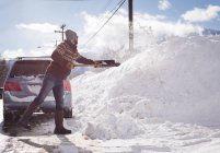 Mann räumt im Winter Schnee mit Schneeschaufel — Stockfoto
