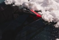 Крупним планом людина прибирає сніг з автомобільного лобового скла — стокове фото