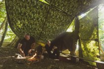 Ajuste homens acendendo fogo no acampamento de inicialização — Fotografia de Stock