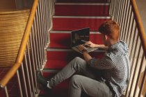 High angle view of college student using laptop on stairs in campus — Stock Photo