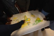 Colegiales mirando el mapa del mundo en el aula en la escuela - foto de stock