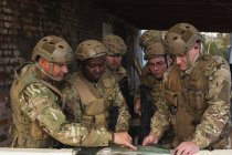 Militares discutiendo el mapa durante el entrenamiento militar - foto de stock