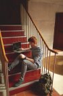 College student using laptop on stairs in campus — Stock Photo