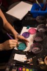 Mittelteil der Frau mischt Farbe mit Pinsel — Stockfoto