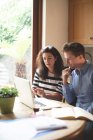 Молода пара обговорює цифровий планшет на кухні вдома — стокове фото