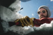 Homme nettoyant la neige du pare-brise de voiture pendant l'hiver — Photo de stock