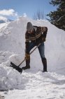 Человек чистит снег лопатой зимой — стоковое фото