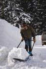Чоловік прибирає сніг зі сніговим штовханням взимку — стокове фото