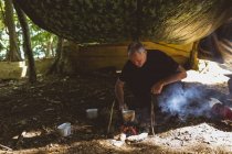 Apto homem cozinhar comida no acampamento de inicialização — Fotografia de Stock