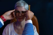 Optometrista che aggiusta occhiali su occhi pazienti in clinica — Foto stock
