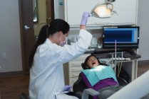 Жіночий стоматолог і медсестра слідчим пацієнта в клініку — стокове фото