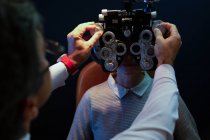Optometrist examining patient eyes with messbrille in clinic — Stock Photo