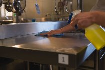 Крупный план повара по чистке столешницы на кухне — стоковое фото