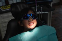 Крупный план пациента, лежащего на стоматологическом стуле в клинике — стоковое фото