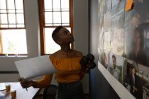 Женщина-руководитель смотрит на фотографии в стене в офисе — стоковое фото