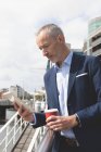 Бізнесмен, використовуючи цифровий планшет на набережній в сонячний день — стокове фото