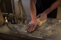 Mid section of chef kneading dough in kitchen at restaurant — Stock Photo