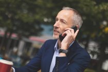 Close-up of businessman talking on mobile phone at outdoor cafe — Stock Photo