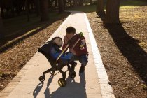 Vater mit seinem kleinen Jungen im Kinderwagen im Park an einem sonnigen Tag — Stockfoto