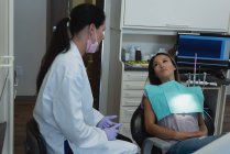 Жіночий стоматолога, взаємодіючи з пацієнта в клініку — стокове фото