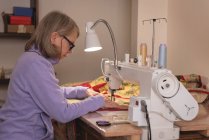 Mulher costura roupas na máquina de costura em casa — Fotografia de Stock
