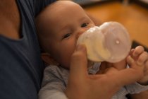 Nahaufnahme des Vaters, der seinen kleinen Jungen zu Hause mit Milch füttert — Stockfoto