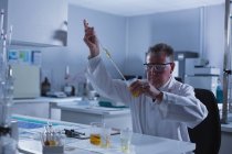 Cientista masculino atento experimentando em laboratório — Fotografia de Stock